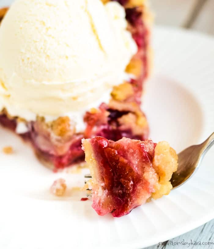 forkful of pie with pie and ice cream in the background