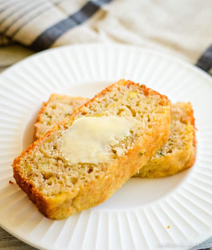 slice of zucchini banana bread spread with butter