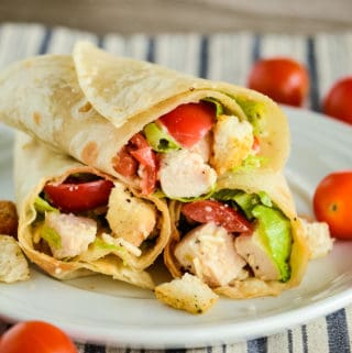 cut in half chicken caesar wrap on white plate