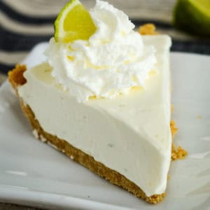 slice of no bake key lime pie with whipped cream and a slice of lime