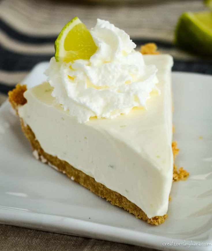 slice of no bake key lime pie with whipped cream and a slice of lime