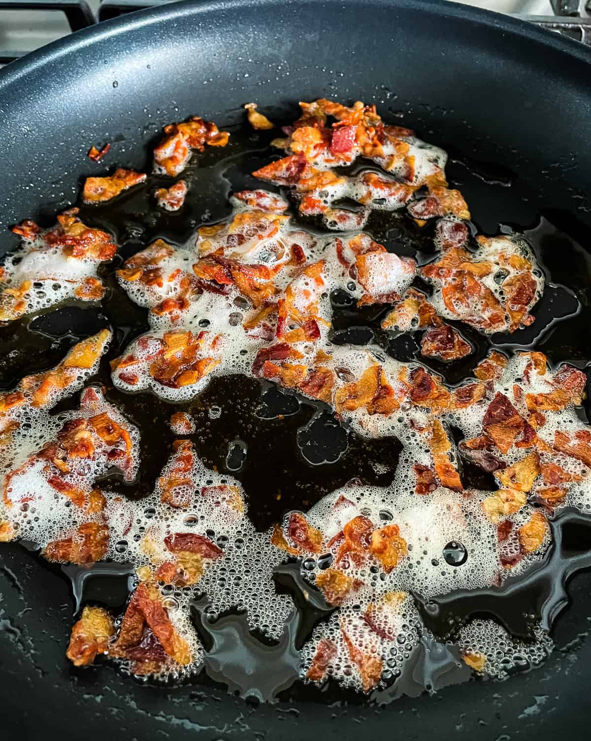 bacon bits cooking in a skillet