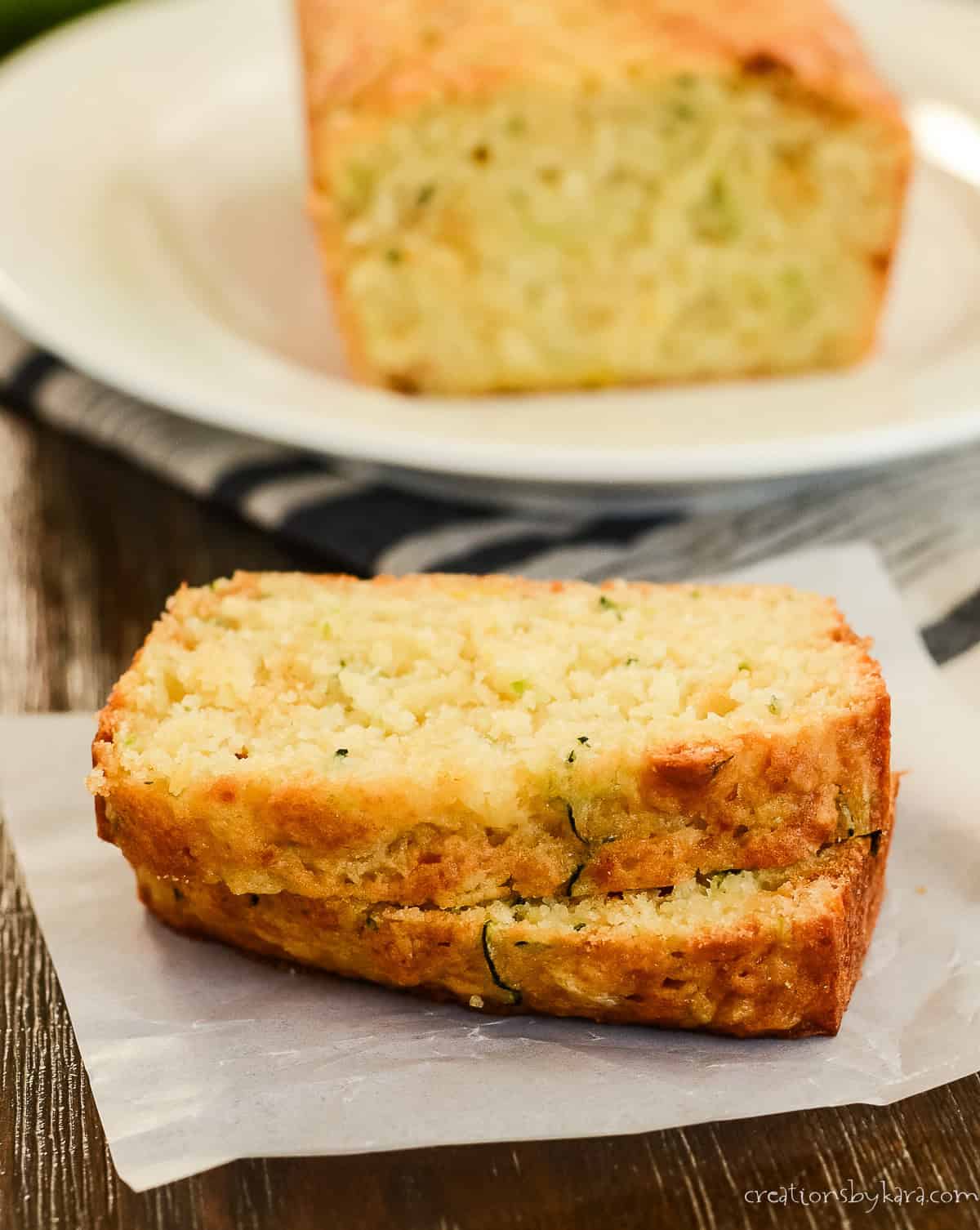 slices of pineapple zucchini bread on a plate with a loaf in the background