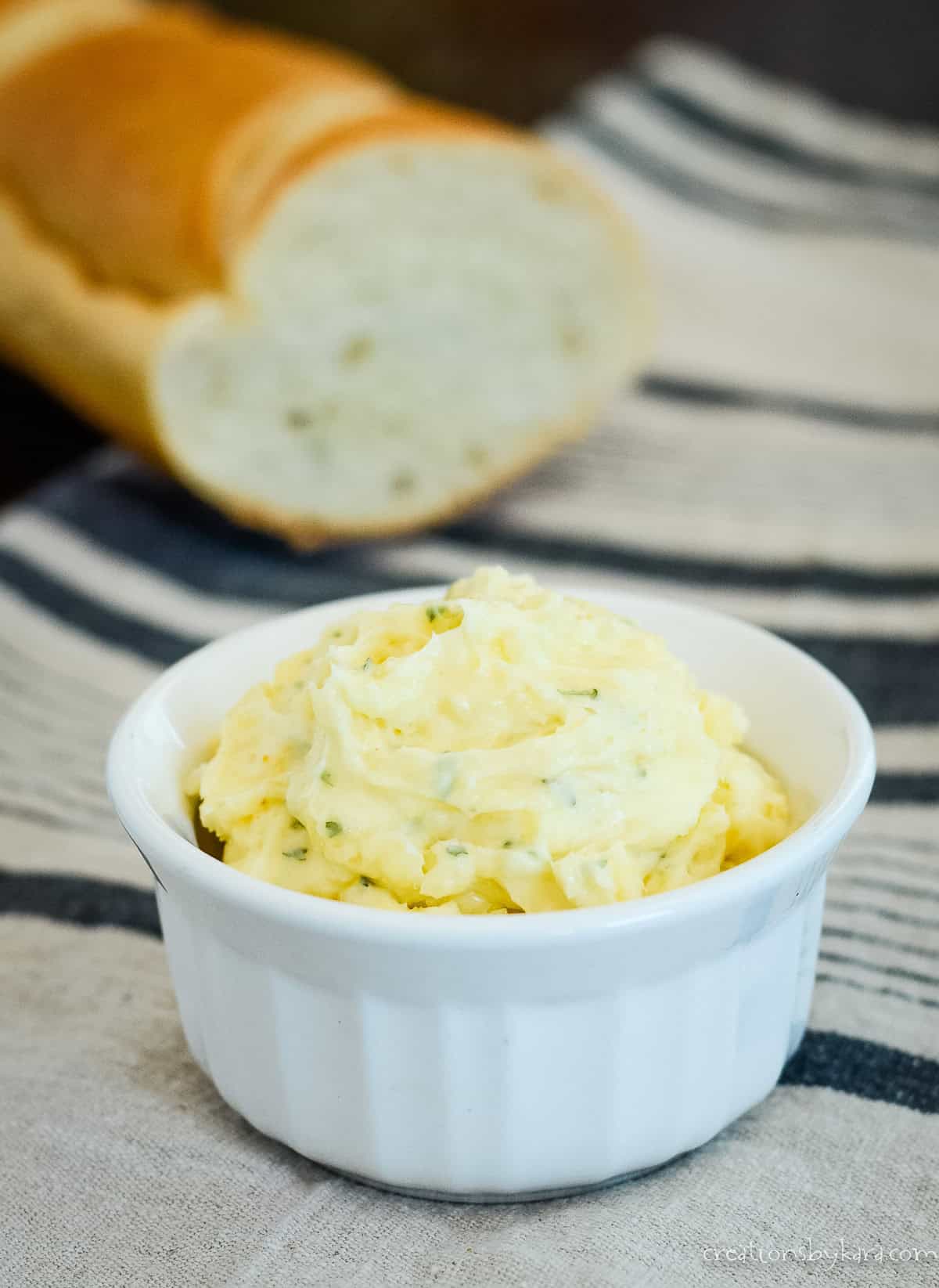 bowl of garlic bread spread with french bread in the background