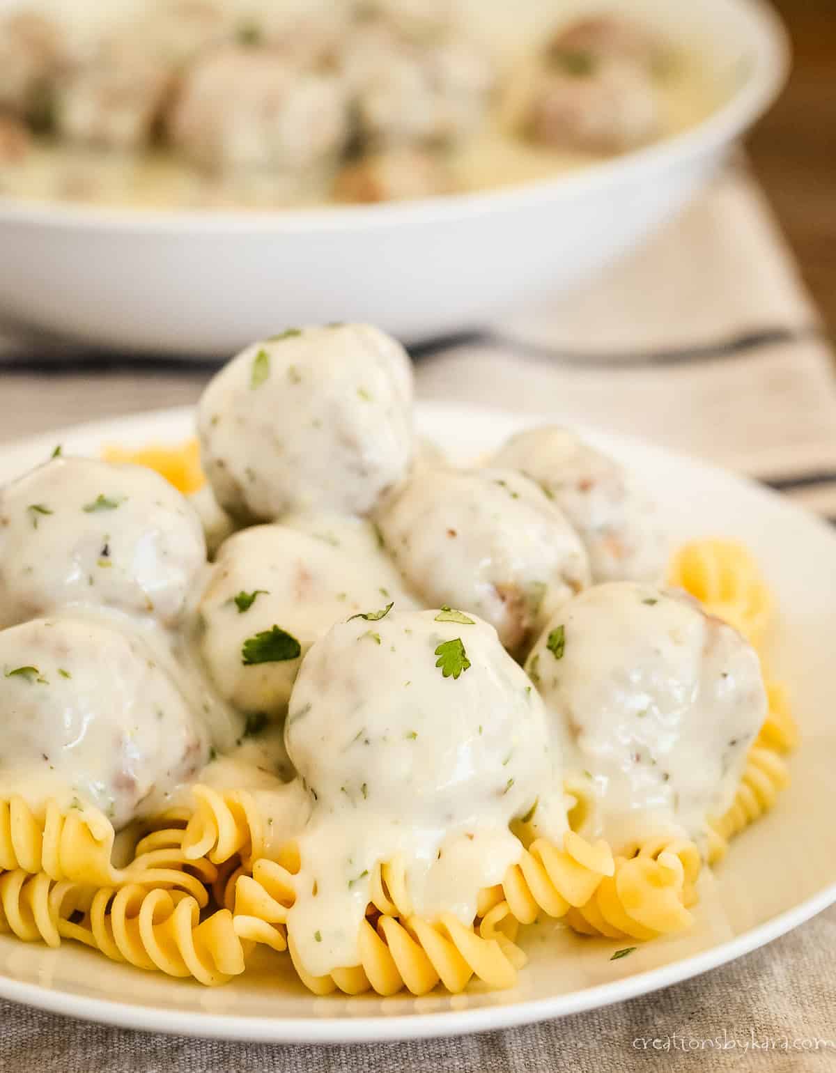 plate of pasta with meatballs in cream sauce