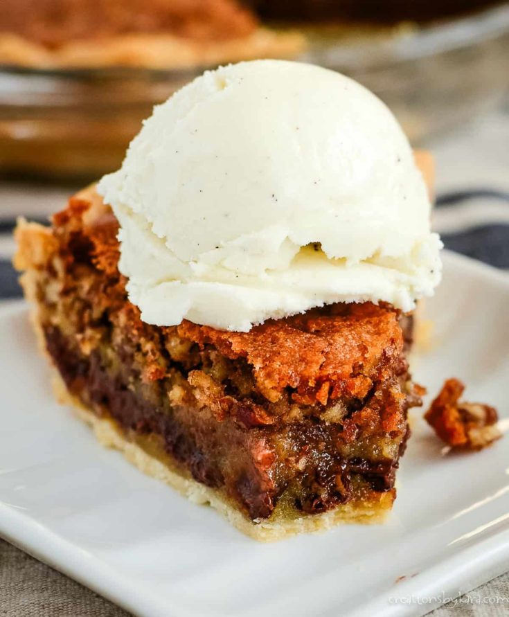 slice of chocolate chip pie with pecans, topped with vanilla ice cream