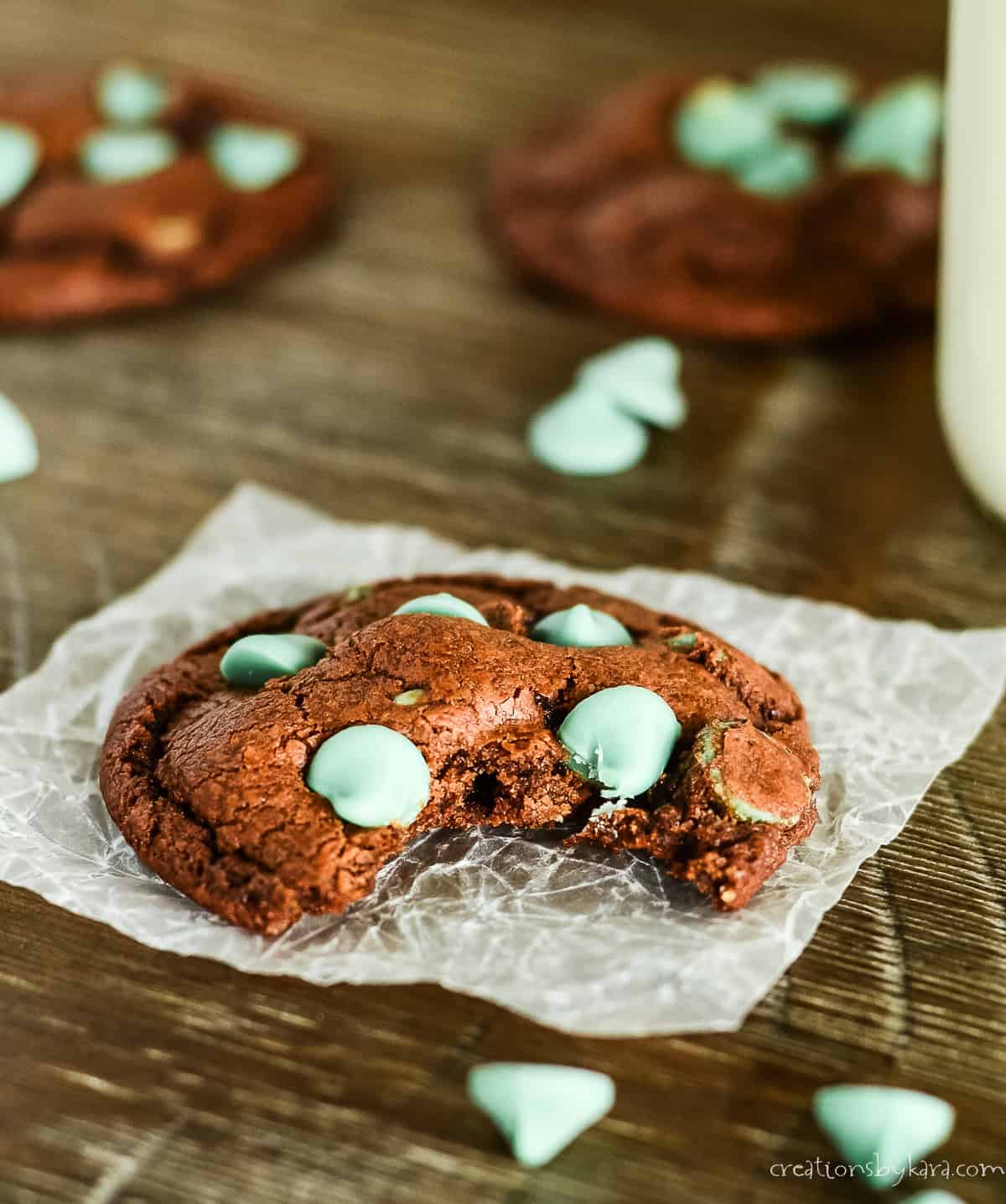 chocolate cookie with mint chips on a piece of waxed paper