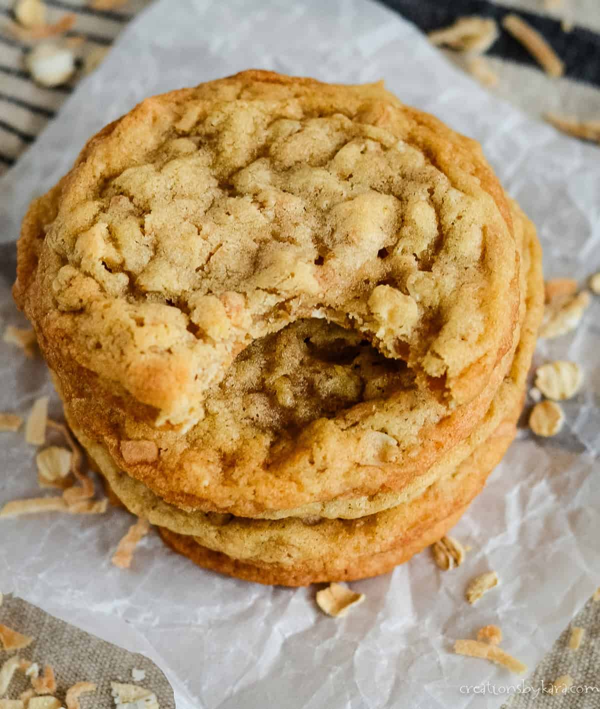 coconut oatmeal cookies, one with a bite taken out of it