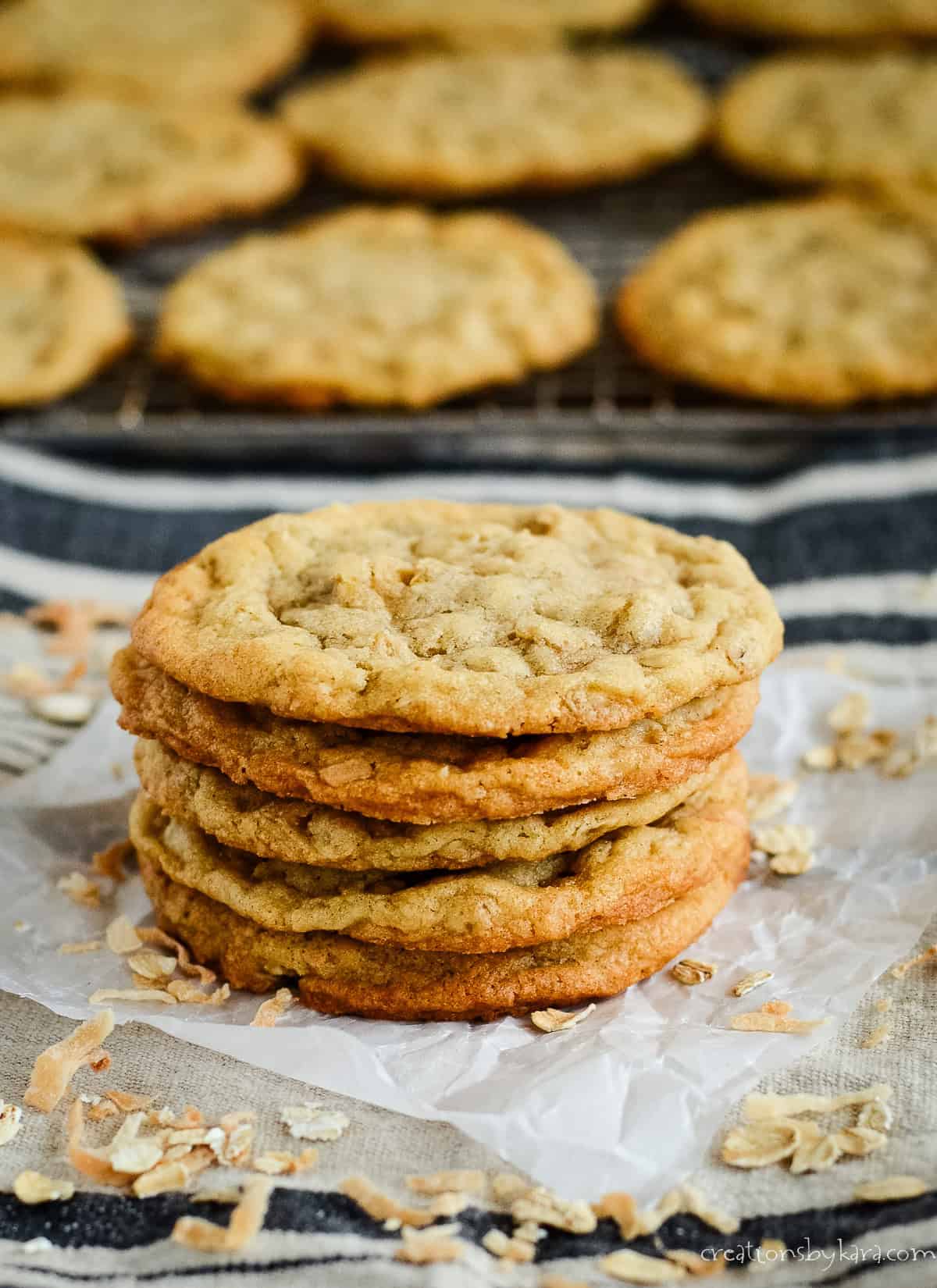 stack of oatmeal coconut cookies with a wire rack in the background